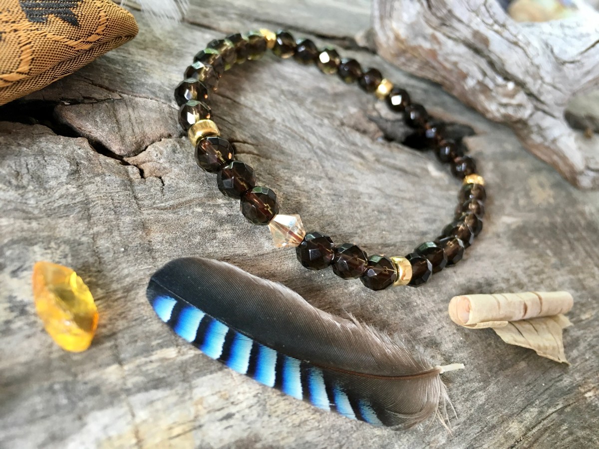 Bastet – Bransoletka Mitycznych Drzew Edenu Marii Bucardi – Kamień Mocy Kwarc Dymny ochrony, rozkwitu jak róża (jeden z pozłacanych elementów). Idealna na problemy ze strachem, atakami ze strony innych,&nbsp;nerwowością